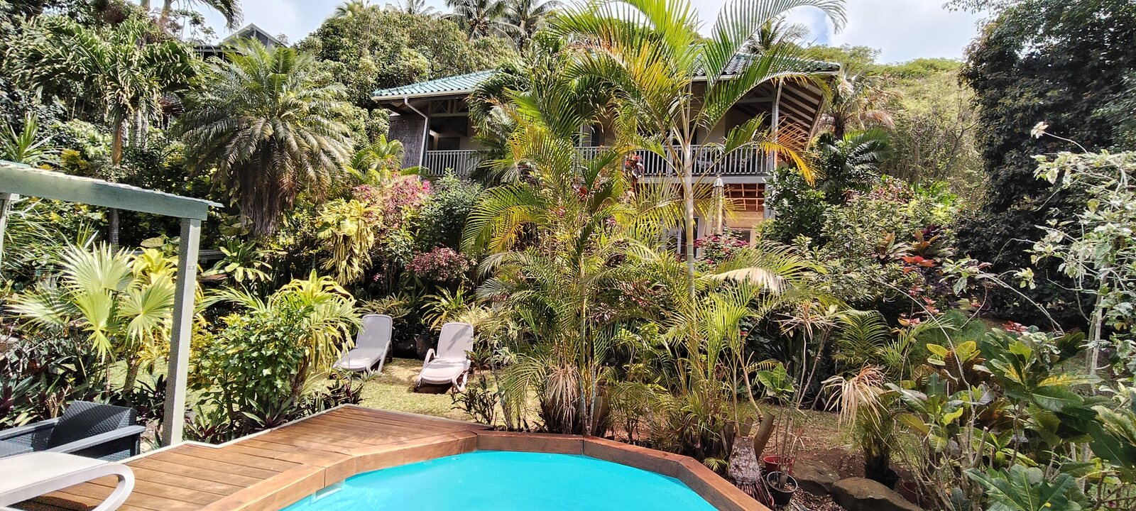 Pool deck overlooking lush tropical gardens and apartments